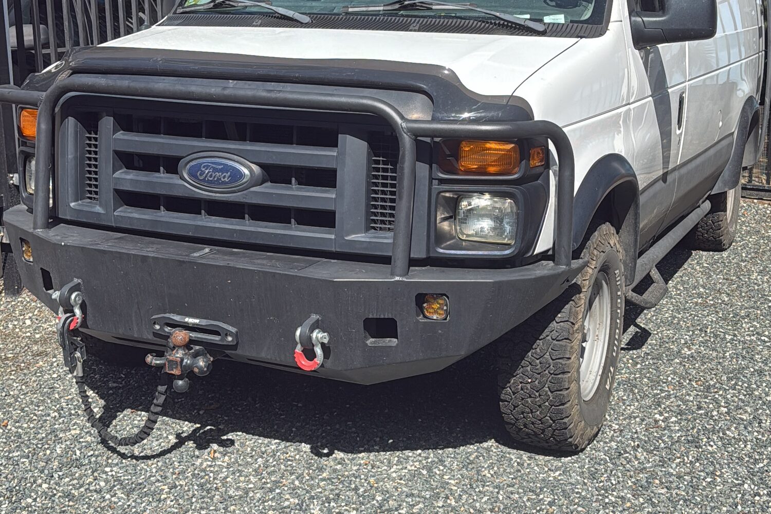Steel front bumper with a winch fairlead, synthetic line, and recovery shackles