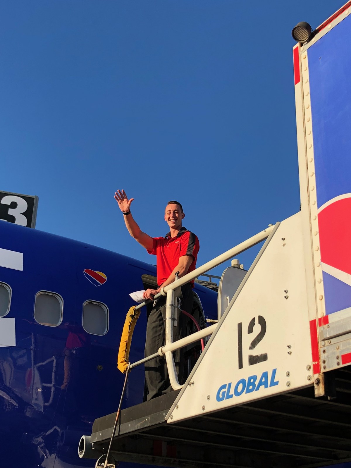 At the top of the airstairs at a Southwest Boeing 737 door, against a clear sky