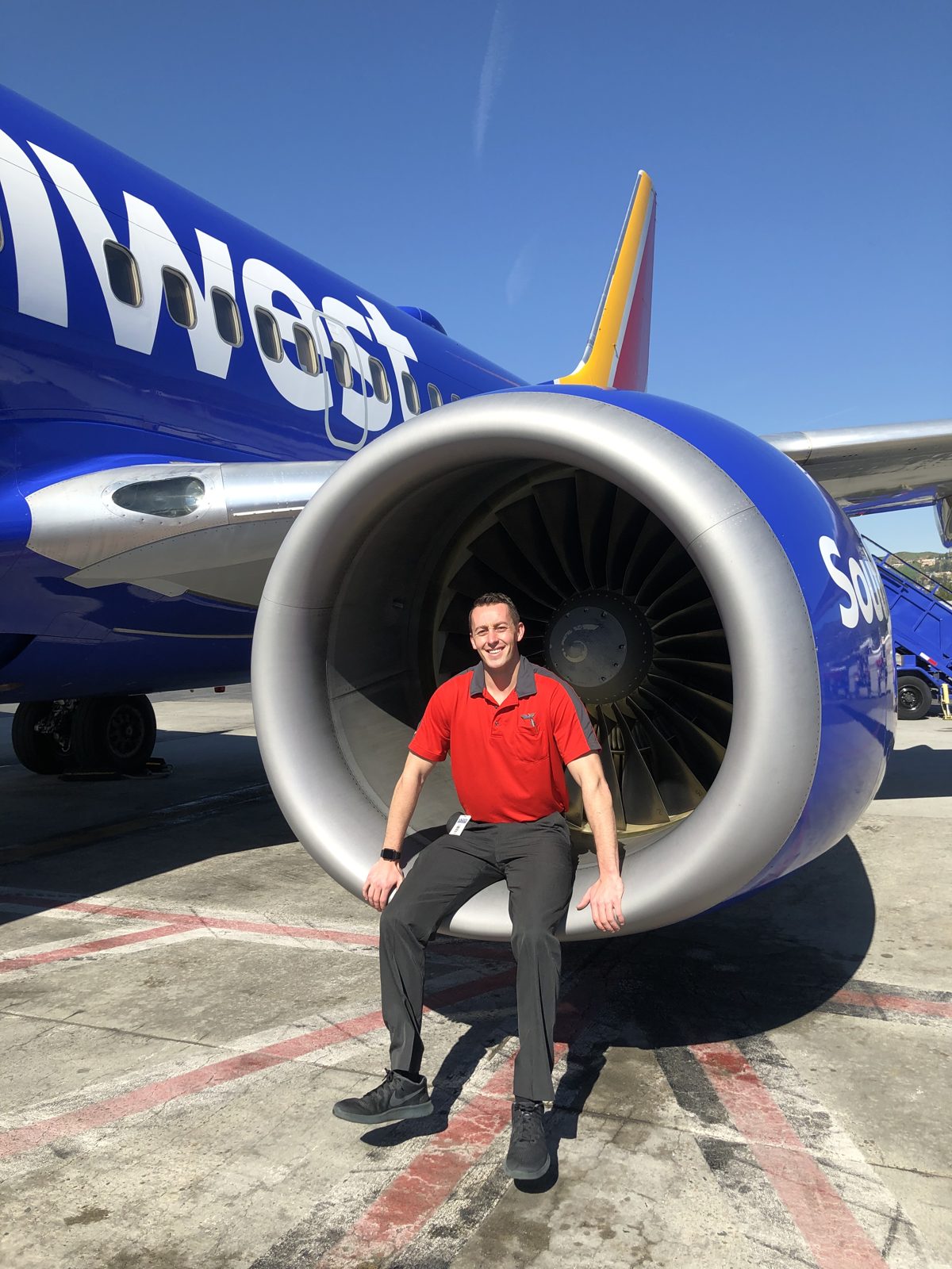 Sitting in the intake cowling of a Southwest 737 engine on the ramp, badge on the belt, turbine visible behind