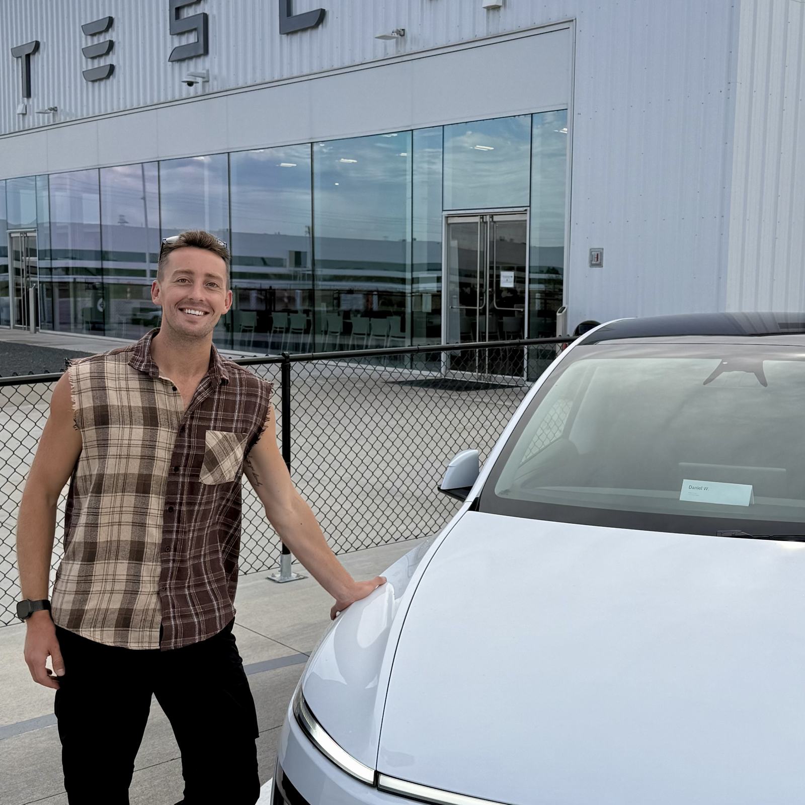 Daniel Weber standing beside his Tesla Model Y