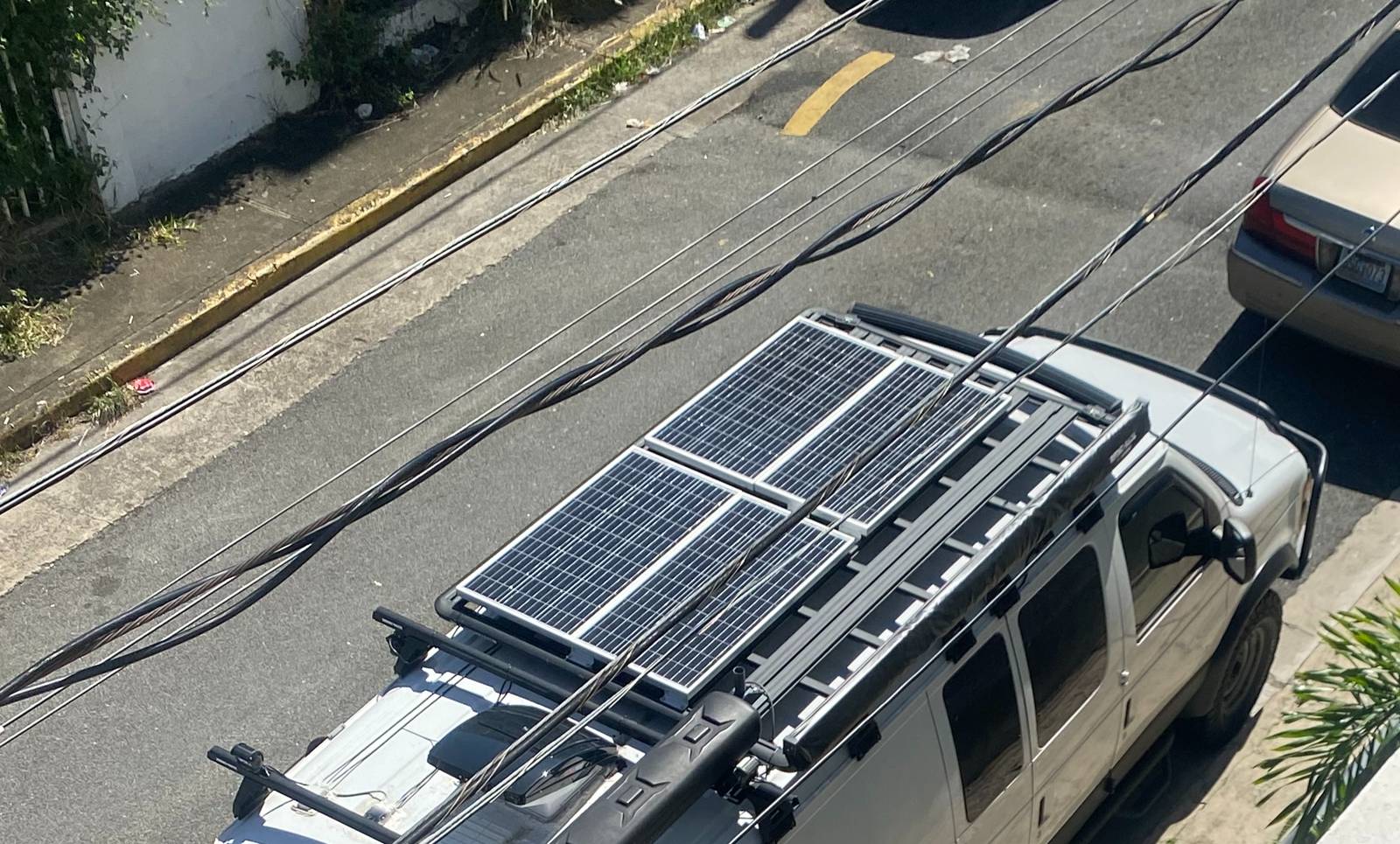 Looking down from above onto the van roof, showing the solar panels laid out and mounted across the roof rack